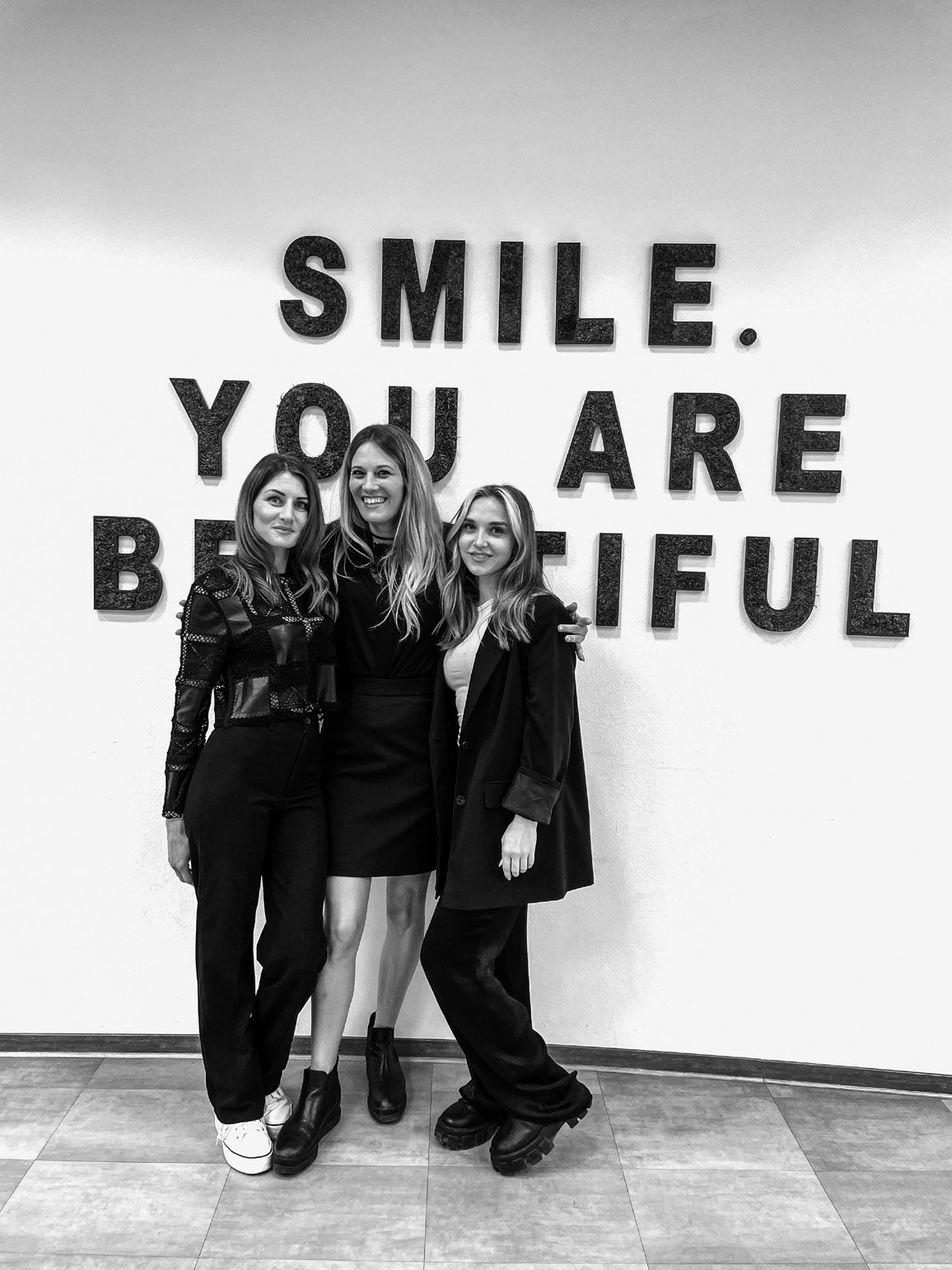 Lena, Annika und Hannah vor der Wand mit dem Schriftzug SMILE. YOU ARE BEAUTIFUL